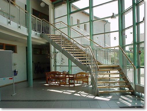 frei tragende Stahltreppe mit beschichtetem Geländer und Holzhandlauf
